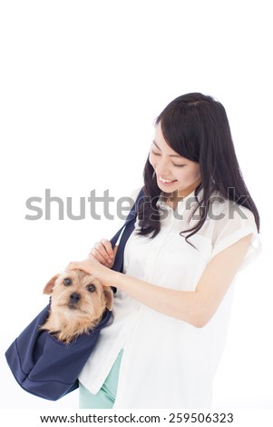 beautiful young woman with Norfolk terrier dog in carry bag, isolated on white background