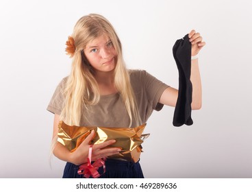 Beautiful Young Woman Not Too Impressed By Her Birthday Or Christmas Present Which Is A Pair Of Black Socks