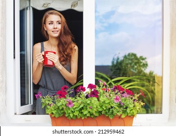 Beautiful Young Woman On A Balcony Enjoing Morning With Cup Of Coffee