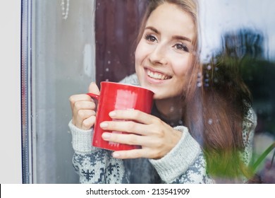 Beautiful young woman on a balcony enjoing morning with cup of coffee - Powered by Shutterstock