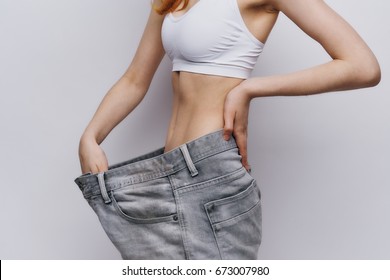 Beautiful Young Woman On A Light Background, Lean. Diet, Losing Weight, Success, Progress.