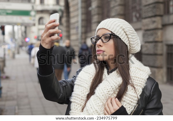 Beautiful young\
woman on the phone in the\
street