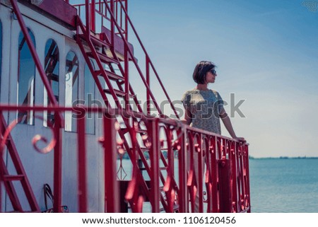 Beautiful young woman on retro vintage steam boat