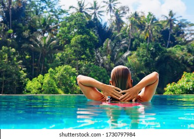 Beautiful Young Woman On Summer Beach Holiday Relaxing In Luxury Spa Hotel In Infinity Swimming Pool With Tropical Jungle View. Healthy Lifestyle, Family Travel Background. Bali Island Summer Tour.