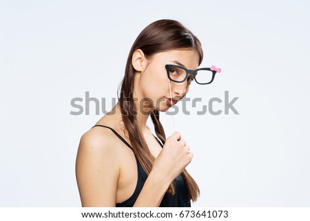 Beautiful young woman on white isolated background holds paper accessories for parties.