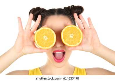 Beautiful young woman with orange halves near eyes on white background