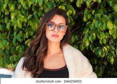 Beautiful young woman outdoor fashion portrait wearing sunglasses.