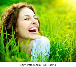Beautiful Young Woman Outdoors. Enjoy Nature. Healthy Smiling Girl in Green Grass.