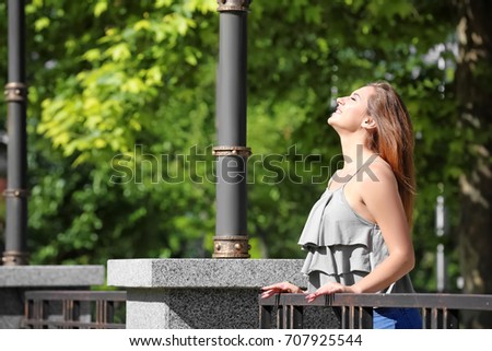 Beautiful young woman outdoors on sunny day