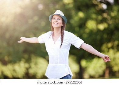 Beautiful young woman outstretching arms and smiling, shallow depth of field - Powered by Shutterstock