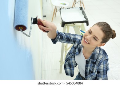 Beautiful Young Woman Painting Wall In Room