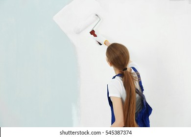 Beautiful Young Woman Painting Wall In Room