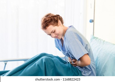 Beautiful Young Woman Patient With Period Pain On Hospital Bed Room.Copy Space.