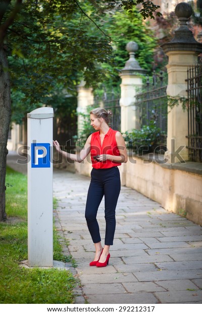 Beautiful young woman\
paying for parking