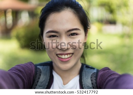 Beautiful young woman photographing herself with phone.