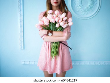 Beautiful Young Woman In Pink Dress Holding Spring Pink Flower Bouquet On The Blue Background In The Morning. 