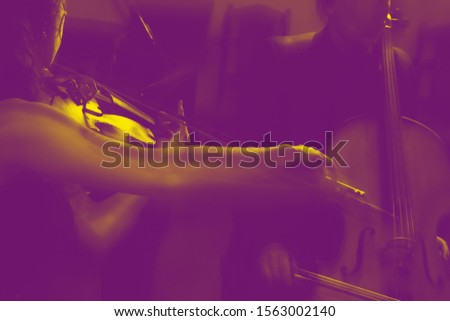  beautiful young woman play violin music instrument. concept of music. Toned  blurred photo in yewith grains for special effect.  
.Sheet music lying on the music stand of the piano in the background
