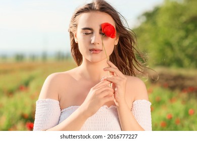 Beautiful Young Woman With Poppy Flower In Field