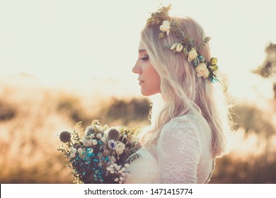 Beautiful Young Woman Portrait In A White Dress In Boho Style With A Floral Wreath In The Summer In The Field. Selective Soft Focus.