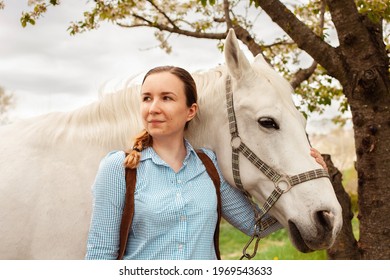 A Beautiful Young Woman Poses Next To A White Horse. Cowboy, Ranch, Village. Love Friendship Concern. Pet. Outside The Door, Green Grass Woods. Sunlight. Blurred Background, Screensaver