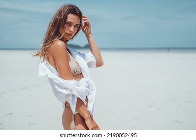 Beautiful young woman posing on the beach with a orange tissue. Happy smiling girl with scarf enjoying at beach. Freedom and carefree concept,Bali, happy face, smile,sport,Yellow color,waves,tanning - Shutterstock ID 2190052495