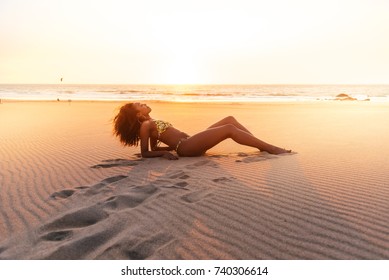Beautiful young woman posing on the sand at the beach