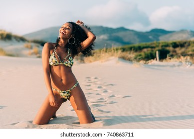 Beautiful young woman posing on the sand in the beach