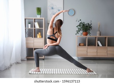 Beautiful Young Woman Practicing Yoga At Home