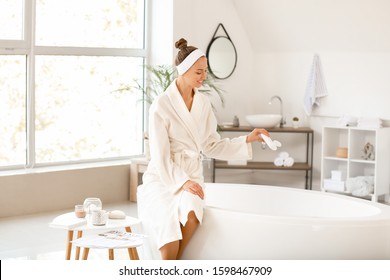 Beautiful young woman preparing relaxing bath - Powered by Shutterstock