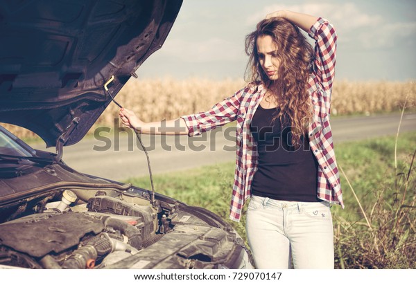 Beautiful young\
woman is a problem with the\
car
