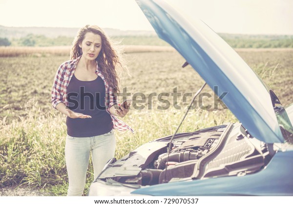 Beautiful young\
woman is a problem with the\
car