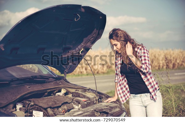 Beautiful young
woman is a problem with the
car