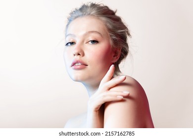 Beautiful Young Woman With Pure Soft Skin, Natural Make-up In Neon Colorfull Light  On Beige Backdrop