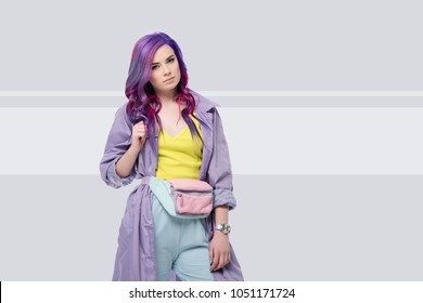 Beautiful Young Woman In Purple Trench Coat With Waist Pack On Creative Background