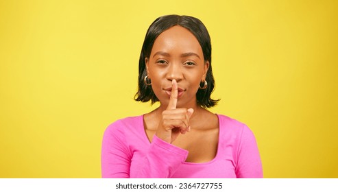Beautiful young woman puts fingers on lips, keep quiet, yellow studio background - Shutterstock ID 2364727755