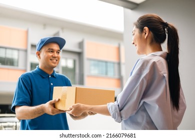 Beautiful Young Woman receiving parcel from blue uniform delivery man f the house with good service from shopping online. Courier man delivering a cardboard box postal package to destination.