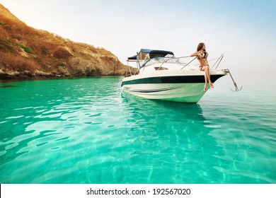 Beautiful young woman recreation on the boat a sunny summer day. Luxury vacation at sea.