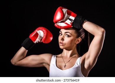 Beautiful young woman in a red boxing gloves over black background - Powered by Shutterstock