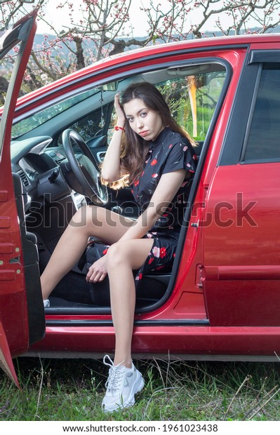 beautiful young woman in red car
