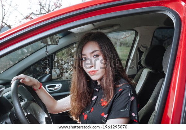 beautiful young woman in red car

