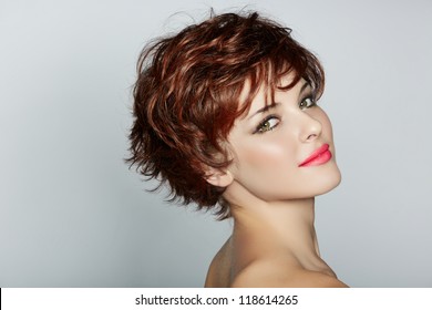 beautiful young woman with red hair wearing short pixie crop hairstyle on studio background