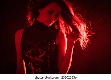 Beautiful Young Woman In Red Light Studio Shot