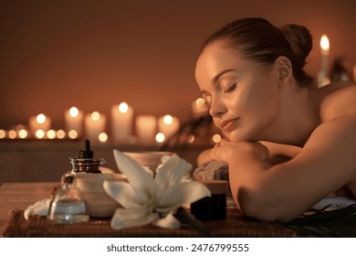 Beautiful young woman relaxing in dark spa salon, closeup