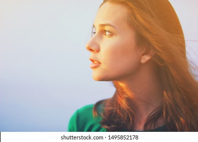 Beautiful Young Woman Relaxing And Enjoying Sun At Sunset. Beauty Sunshine Girl Side Profile Portrait. Pretty Happy Lady Enjoying Summer Outdoors. Positive Emotion Life Success Mind Peace Concept