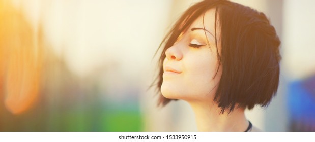 Beautiful young woman relaxing and enjoying sun at sunset. Beauty sunshine girl side profile portrait. Pretty happy woman enjoying summer outdoors. Positive emotion life success mind peace concept. - Shutterstock ID 1533950915