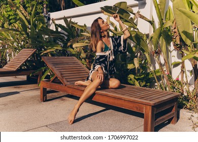 Beautiful  Young Woman Relaxing  On Private Villa Near Pool. Boho Chic,style And Beauty, Fashionable Girl,accessory Store. Tropical Stile. 