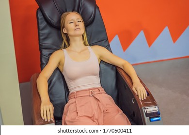 Beautiful Young Woman Relaxing On The Massage Chair In Airport Or In The Mall