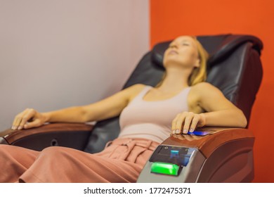 Beautiful Young Woman Relaxing On The Massage Chair In Airport Or In The Mall