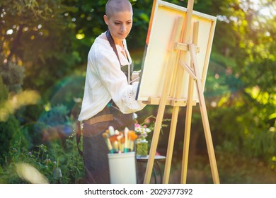 Beautiful young woman relaxing while painting an art canvas outdoors in her garden. Cancer survivor, mindfulness, art therapy, creativity concept. - Powered by Shutterstock