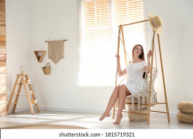 Beautiful young woman resting in hammock chair at home - Powered by Shutterstock